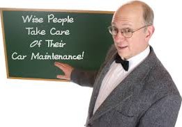 Man with sign about wisdom of car maintenance