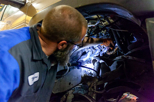 Auto Repair Technician working on a vehicle at Integrity Auto Services